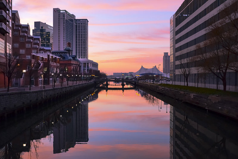 The sun rises as the Jones Falls empties into Baltimore's inner harbor.