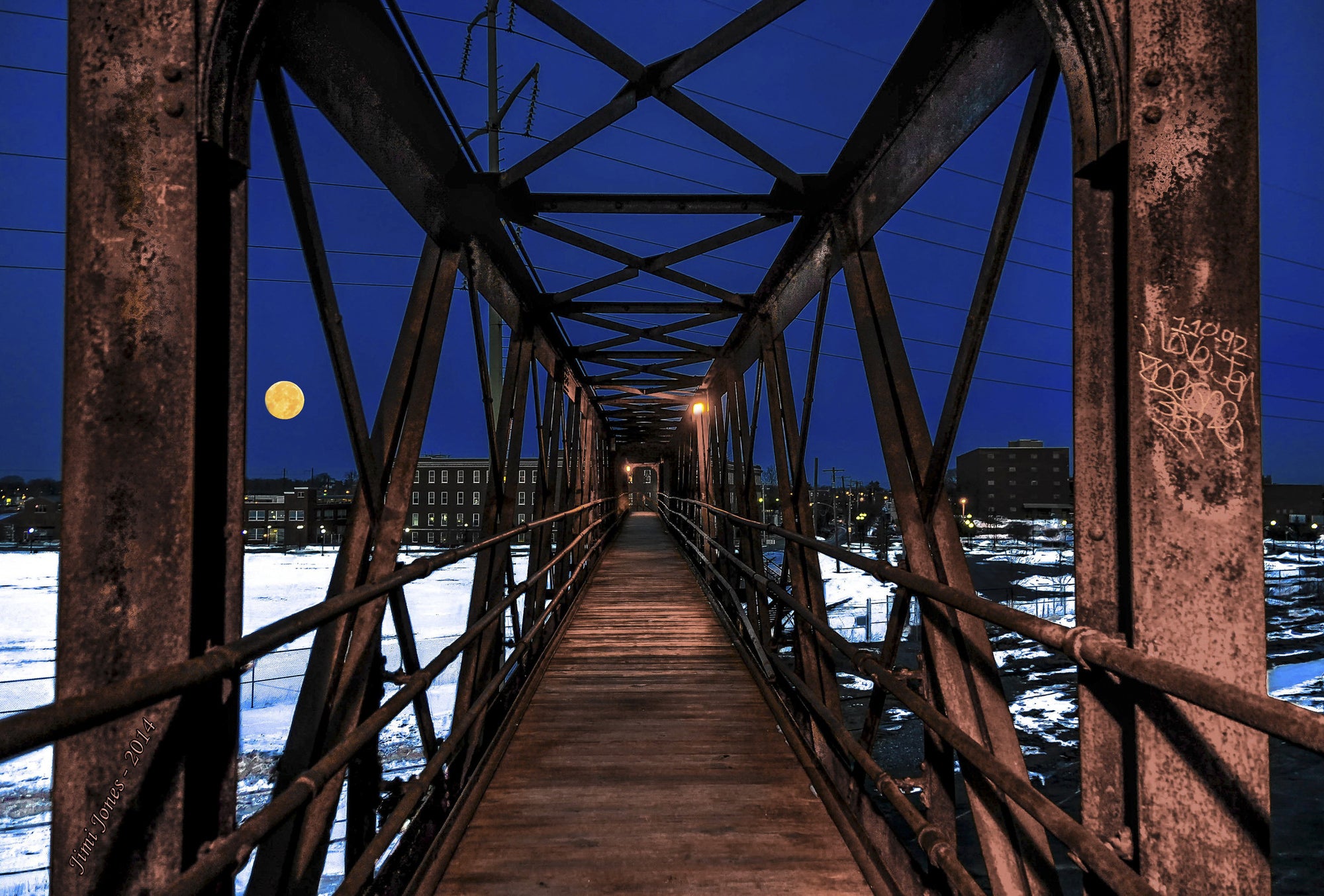 A full moon shine over a pedestrian bridge.
