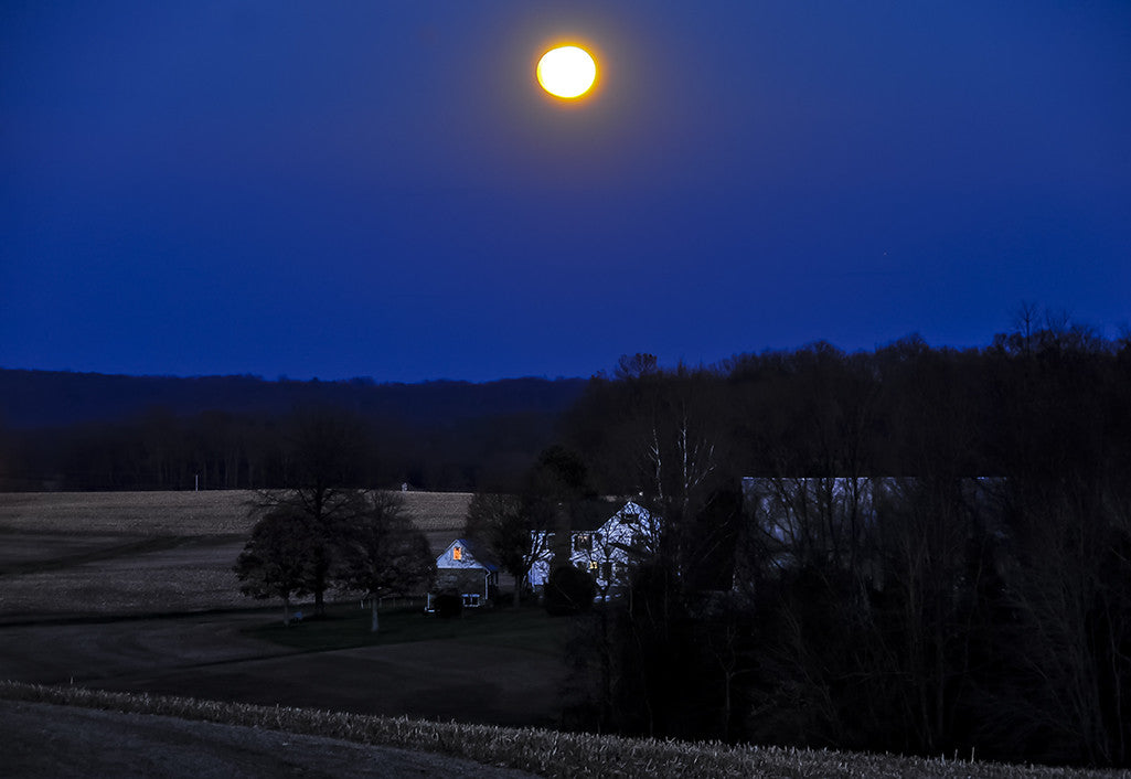 A rising moon shines brightly over a farm in Baltimore County.