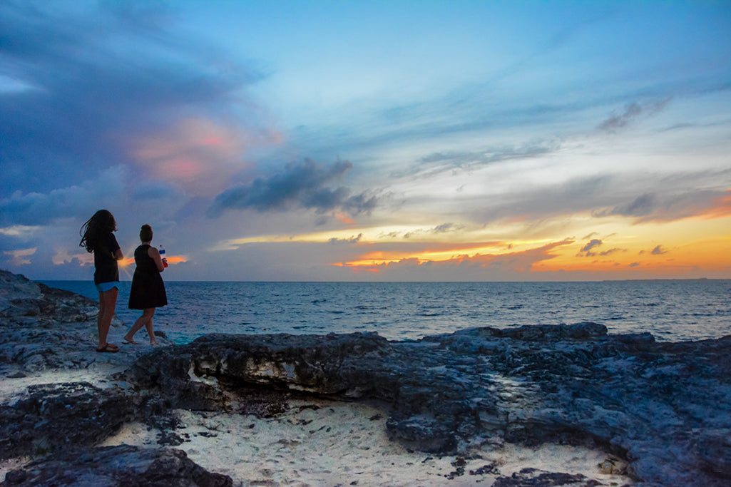 Ladies stand witness to Mother Nature's transitioning sky along the coast of the Caribbean Sea.